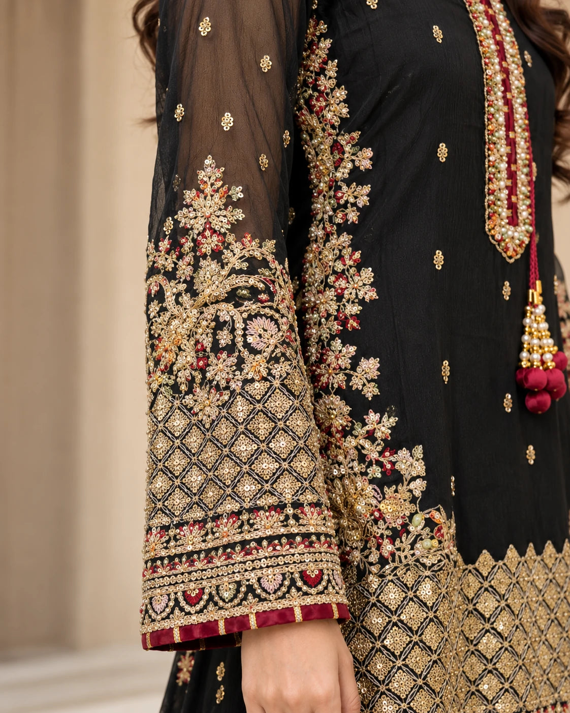 Black sheer sleeves with intricate gold floral embroidery, geometric patterns and maroon cuffs