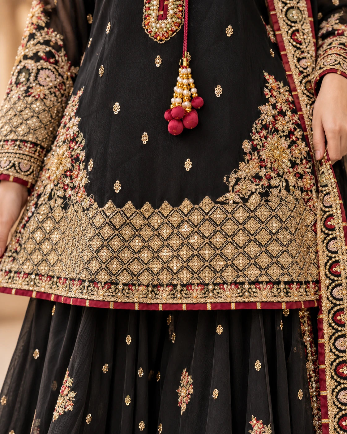 Detailed gold diamond lattice embroidery on black Pakistani kameez with floral embellishments