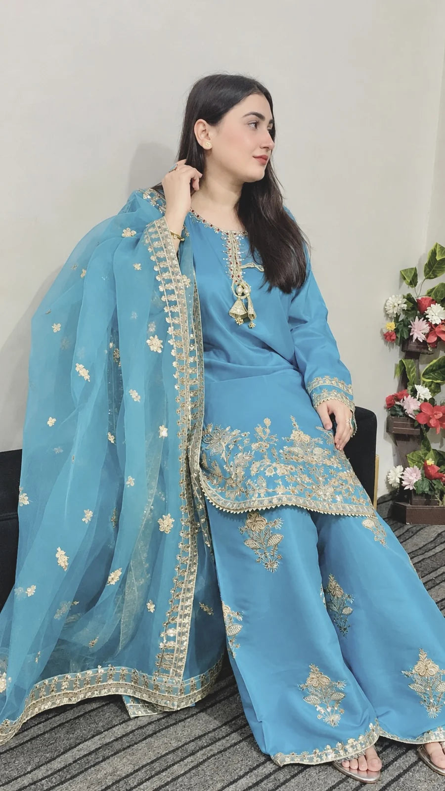 Model wearing a sky blue China silk Farshi Shalwar 3-piece suit with golden embroidery and an organza dupatta.